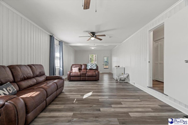 living area featuring a ceiling fan, crown molding, baseboards, and wood finished floors