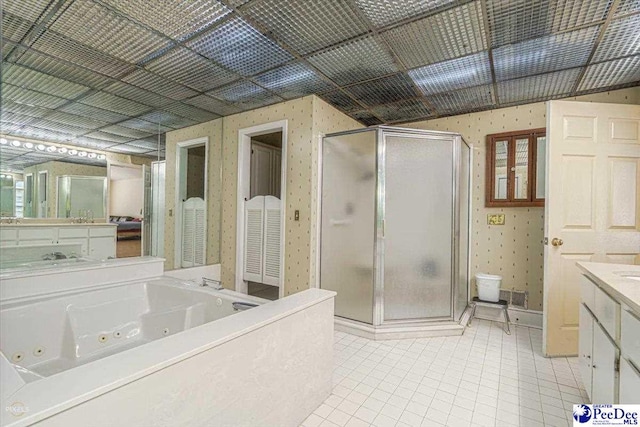 bathroom featuring tile patterned flooring, shower with separate bathtub, and vanity