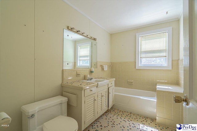 bathroom featuring tile walls, a tub to relax in, vanity, and a wealth of natural light