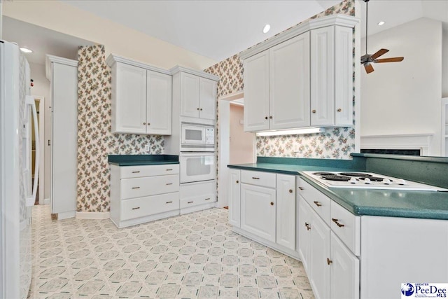 kitchen with white appliances, light floors, a ceiling fan, white cabinets, and dark countertops