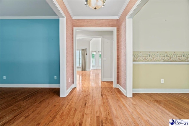 interior space with baseboards, ornamental molding, and light wood-type flooring