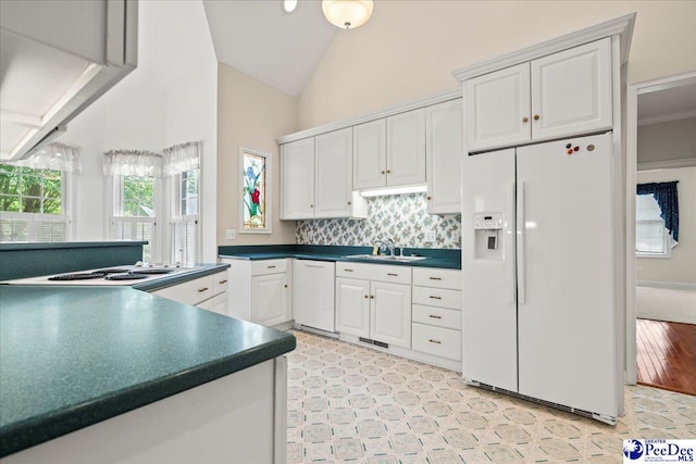 kitchen featuring white appliances, white cabinets, dark countertops, and a sink