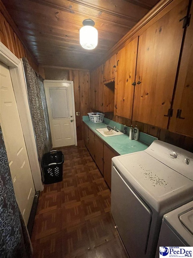 clothes washing area with dark parquet flooring, sink, cabinets, separate washer and dryer, and wooden ceiling