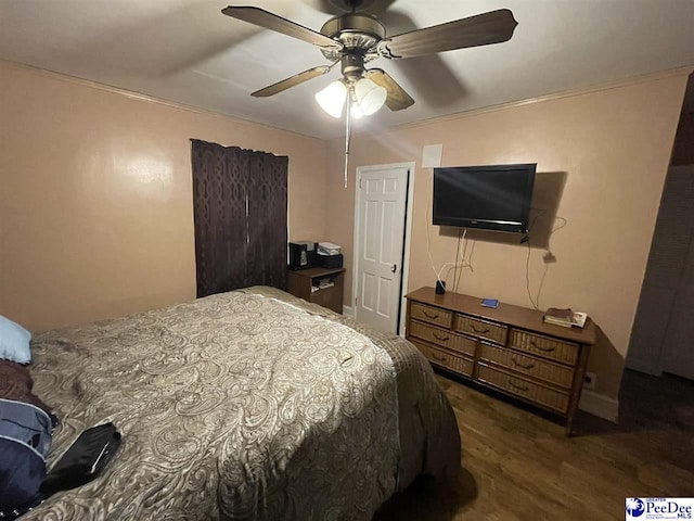 bedroom with crown molding, dark wood-type flooring, and ceiling fan