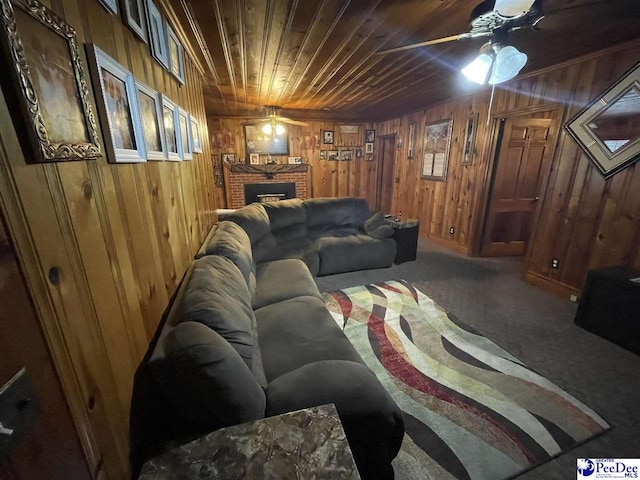 living room featuring ceiling fan, wood walls, a brick fireplace, and wooden ceiling