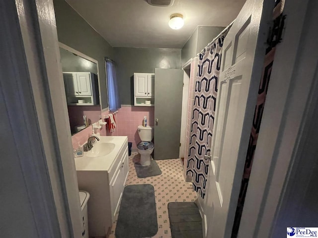 bathroom featuring a shower with curtain, vanity, tile walls, and toilet