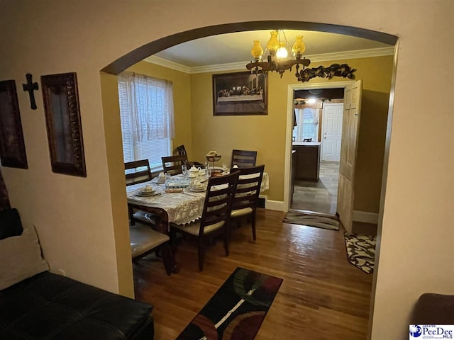 dining room with an inviting chandelier, hardwood / wood-style floors, and ornamental molding