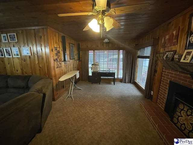 carpeted living room with a fireplace, wooden ceiling, ceiling fan, and wood walls