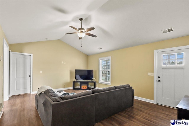 living room featuring ceiling fan, dark hardwood / wood-style flooring, and vaulted ceiling