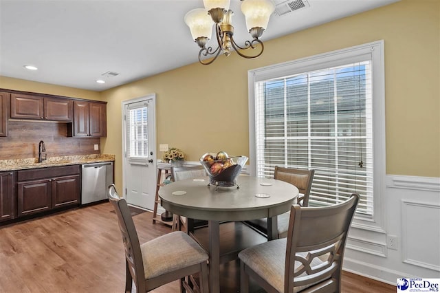 dining room featuring an inviting chandelier, sink, and hardwood / wood-style floors