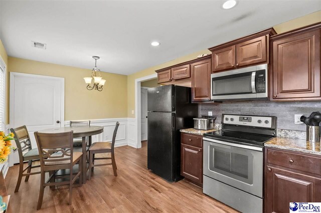 kitchen with tasteful backsplash, an inviting chandelier, hanging light fixtures, light hardwood / wood-style flooring, and appliances with stainless steel finishes