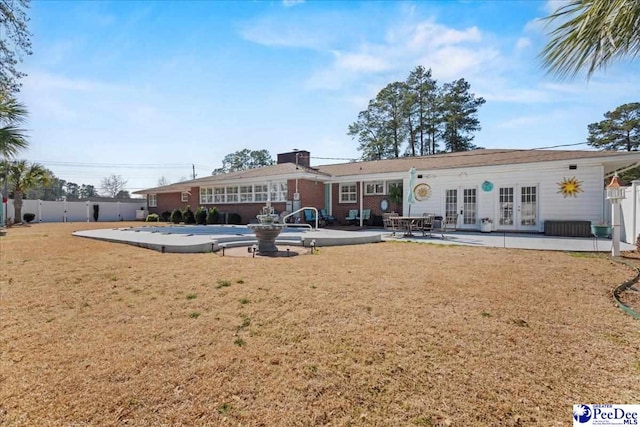 rear view of property featuring a yard, french doors, a patio area, and fence