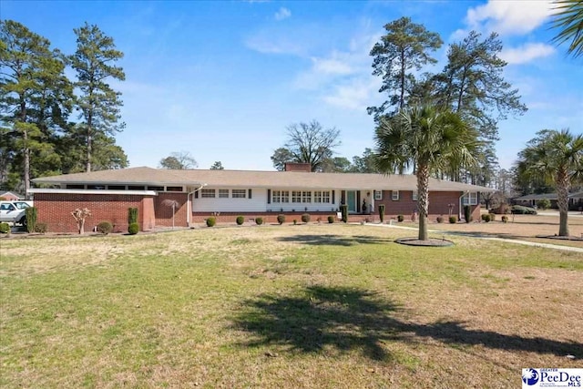 single story home with brick siding, a chimney, and a front lawn