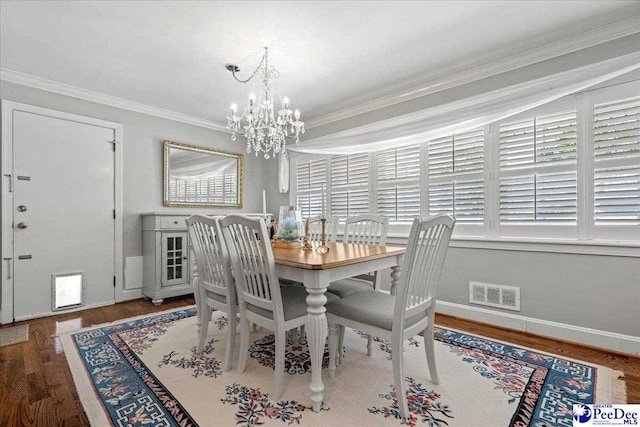 dining room with baseboards, visible vents, crown molding, and wood finished floors