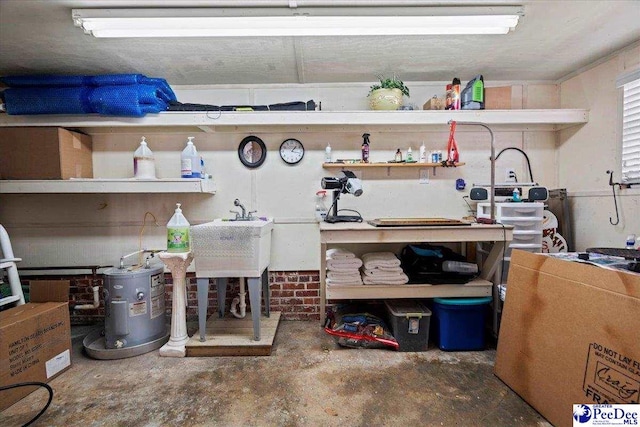 garage with water heater, a workshop area, and a sink