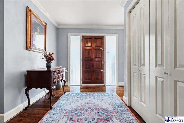 entrance foyer featuring ornamental molding, dark wood-type flooring, and baseboards