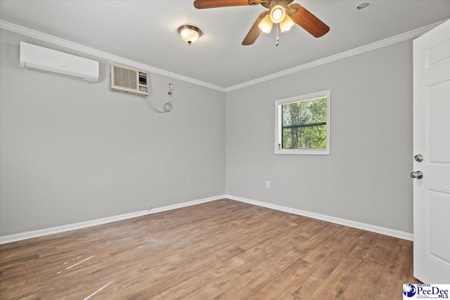 empty room with crown molding, baseboards, a wall mounted AC, and wood finished floors