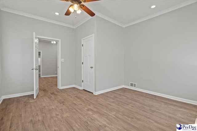 unfurnished bedroom with light wood finished floors, baseboards, visible vents, and ornamental molding