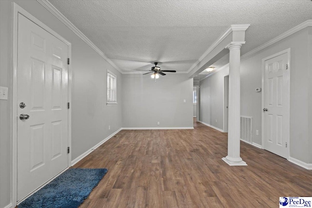 interior space with crown molding, ornate columns, visible vents, a ceiling fan, and wood finished floors