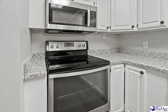 kitchen featuring white cabinetry, light stone countertops, and stainless steel appliances