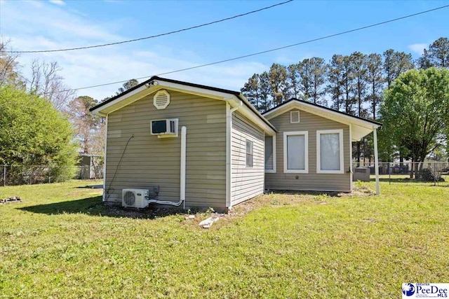 rear view of house with ac unit, fence, and a yard