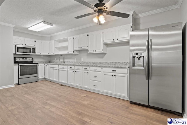 kitchen with white cabinets, stainless steel appliances, crown molding, and light wood finished floors