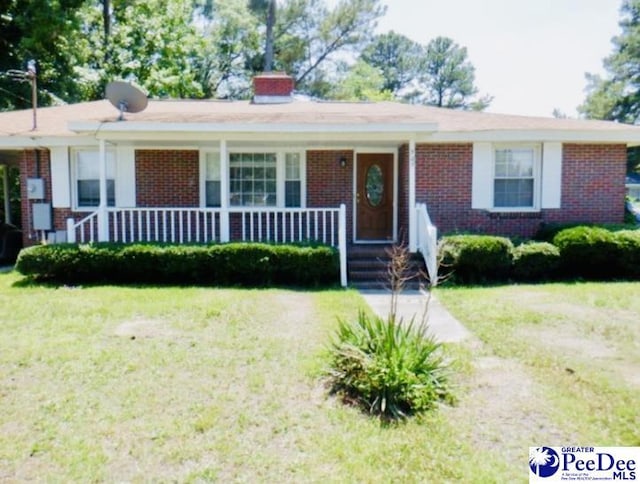 507 W Washington St, Dillon, SC 29536 - ranch-style house featuring brick siding, a front yard, covered porch, and a chimney