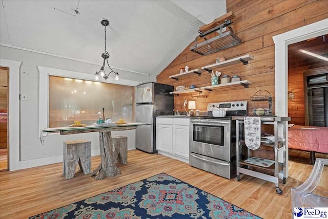 kitchen with lofted ceiling, light hardwood / wood-style flooring, appliances with stainless steel finishes, white cabinetry, and hanging light fixtures