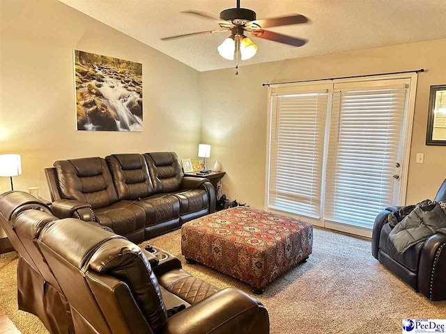 living room with a textured ceiling, ceiling fan, vaulted ceiling, and carpet