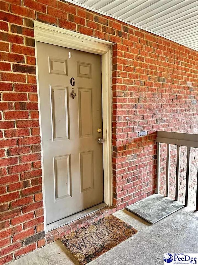 doorway to property with brick siding