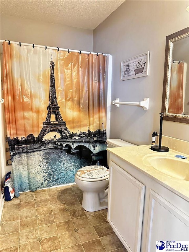 full bath with a textured ceiling, toilet, and vanity