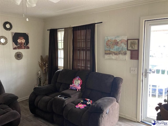 living room with crown molding, plenty of natural light, and wood-type flooring