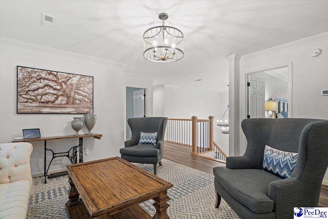 living room featuring hardwood / wood-style flooring, ornamental molding, and a chandelier