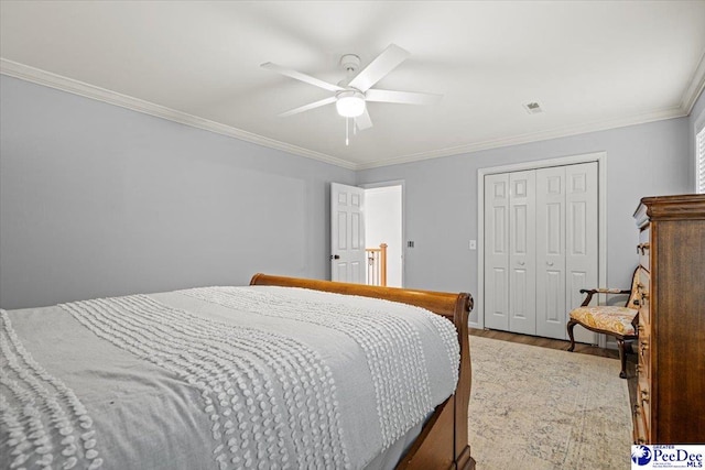 bedroom with crown molding, hardwood / wood-style floors, ceiling fan, and a closet