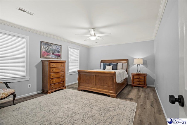 bedroom with crown molding, ceiling fan, and dark hardwood / wood-style flooring