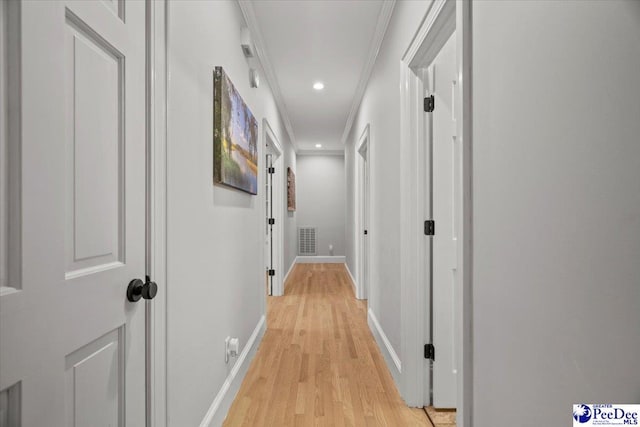 corridor featuring crown molding and light hardwood / wood-style flooring