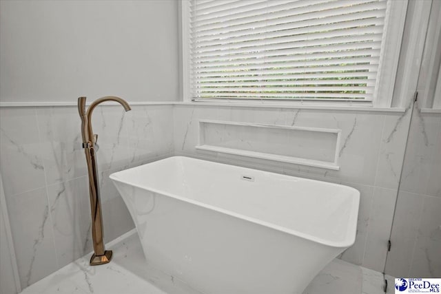 bathroom with tile walls and a bathtub