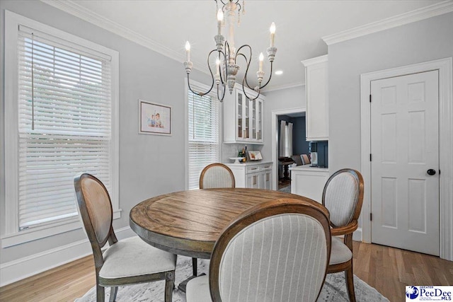 dining area with crown molding, light hardwood / wood-style floors, and a chandelier