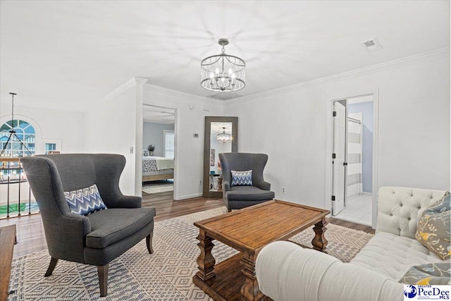 living room with crown molding, light hardwood / wood-style flooring, and a notable chandelier