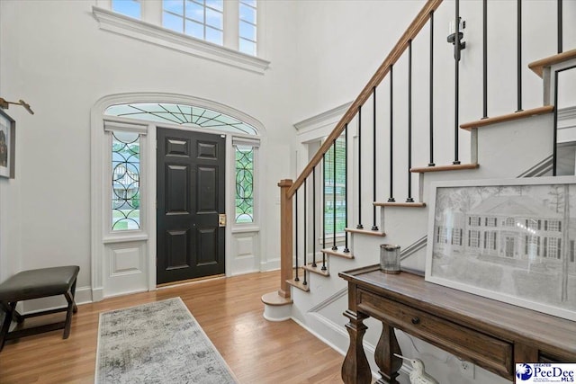 foyer featuring a towering ceiling and light hardwood / wood-style floors