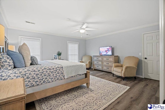 bedroom with multiple windows, crown molding, dark wood-type flooring, and ceiling fan