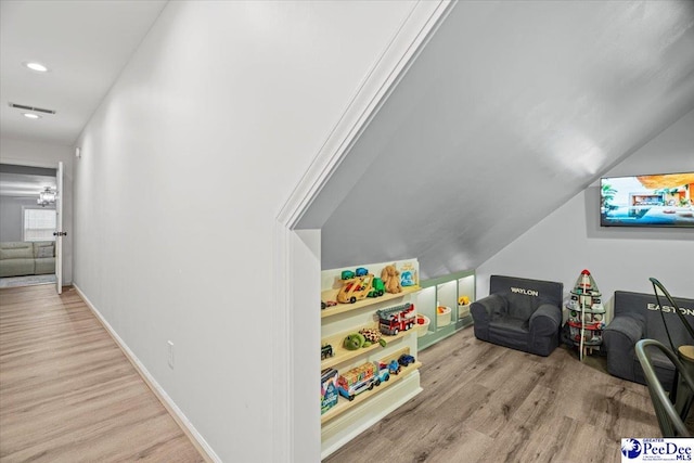 rec room with lofted ceiling and light hardwood / wood-style floors