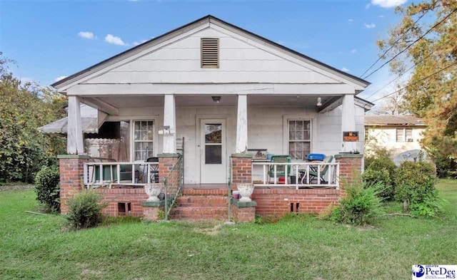 view of front of home with a front yard and a porch