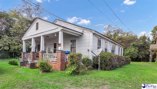 view of front of property featuring a front yard and covered porch