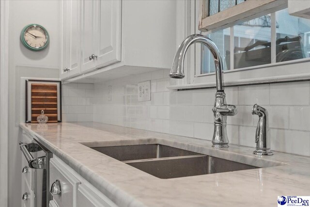 965 Scriven Dr, Flornce, SC 29501 - kitchen featuring a sink, white cabinets, backsplash, and light stone countertops