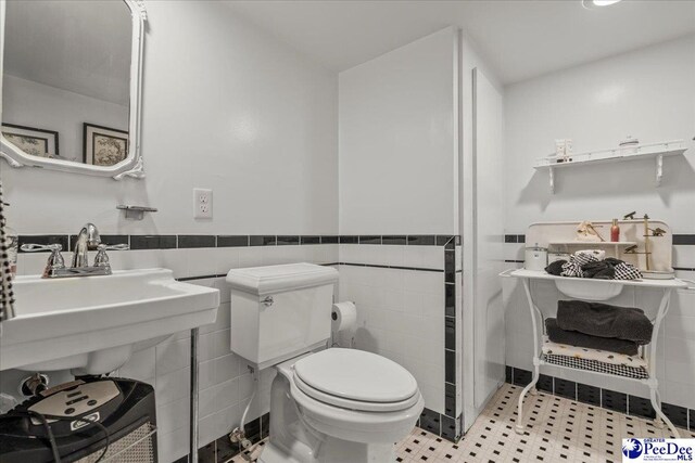 965 Scriven Dr, Flornce, SC 29501 - bathroom featuring toilet, a wainscoted wall, and tile walls