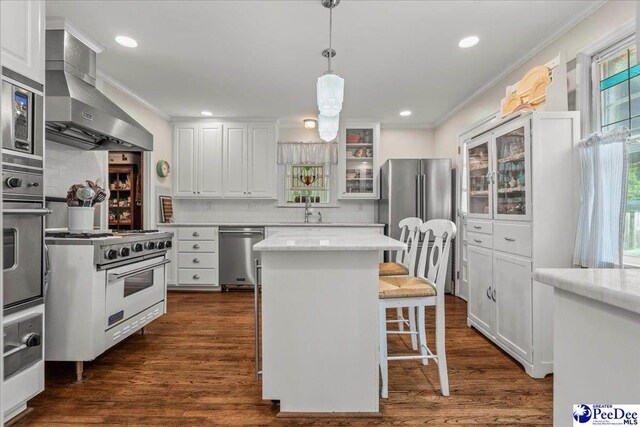 965 Scriven Dr, Flornce, SC 29501 - kitchen featuring stainless steel appliances, wall chimney range hood, ornamental molding, backsplash, and white cabinets