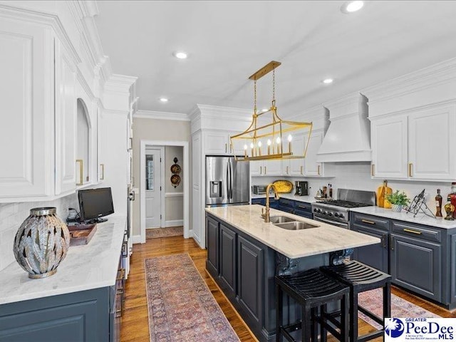 kitchen with a sink, white cabinetry, appliances with stainless steel finishes, custom exhaust hood, and decorative backsplash