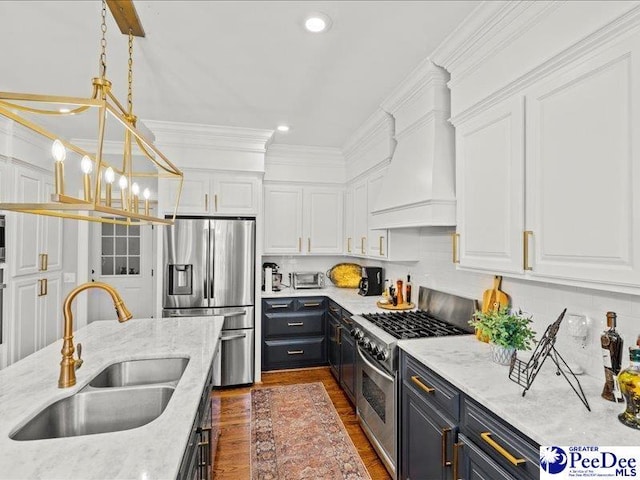 kitchen with stainless steel appliances, white cabinetry, and a sink