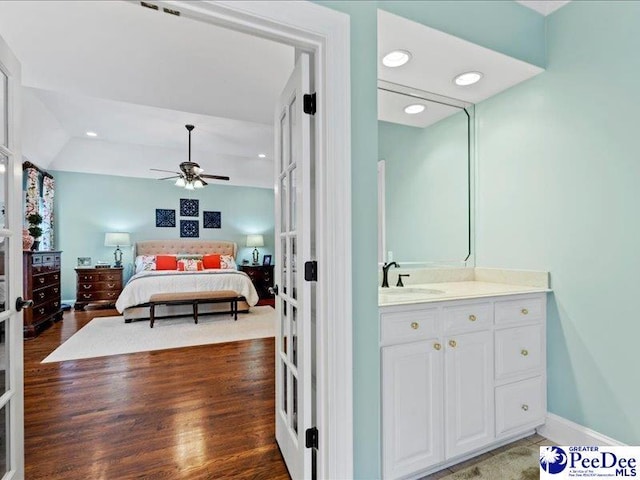 bedroom featuring recessed lighting, dark wood-style flooring, a sink, a ceiling fan, and baseboards